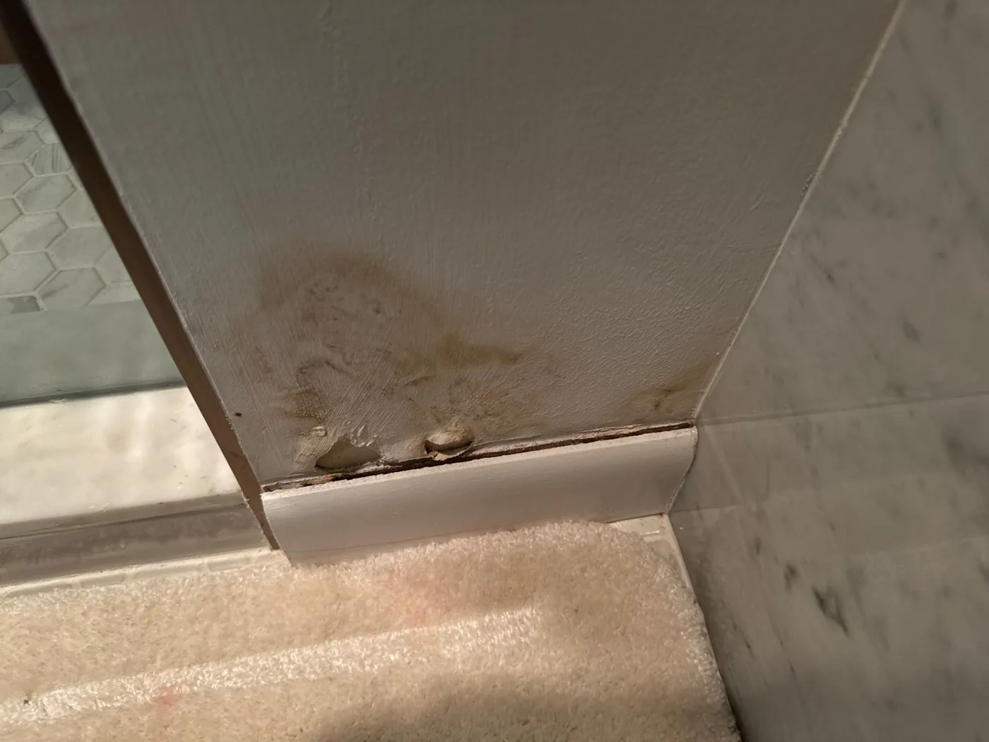 Water staining on a bathroom baseboard during a Boynton Beach, FL mold inspection