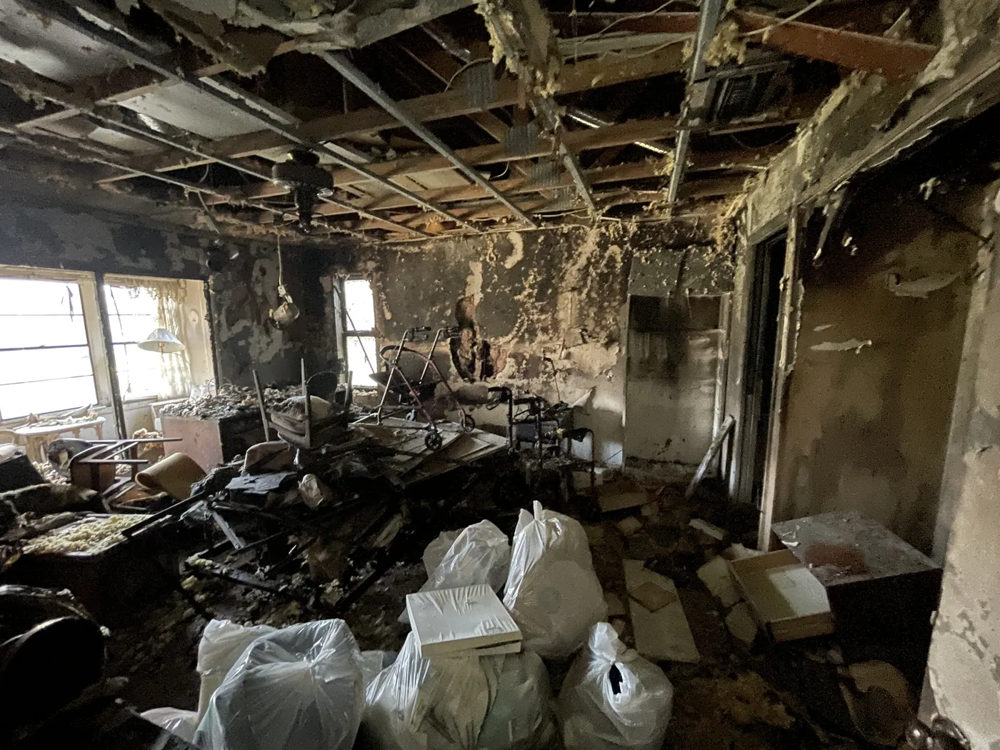 Fire and smoke damage throughout a living room documented during a pre-remediation inspection