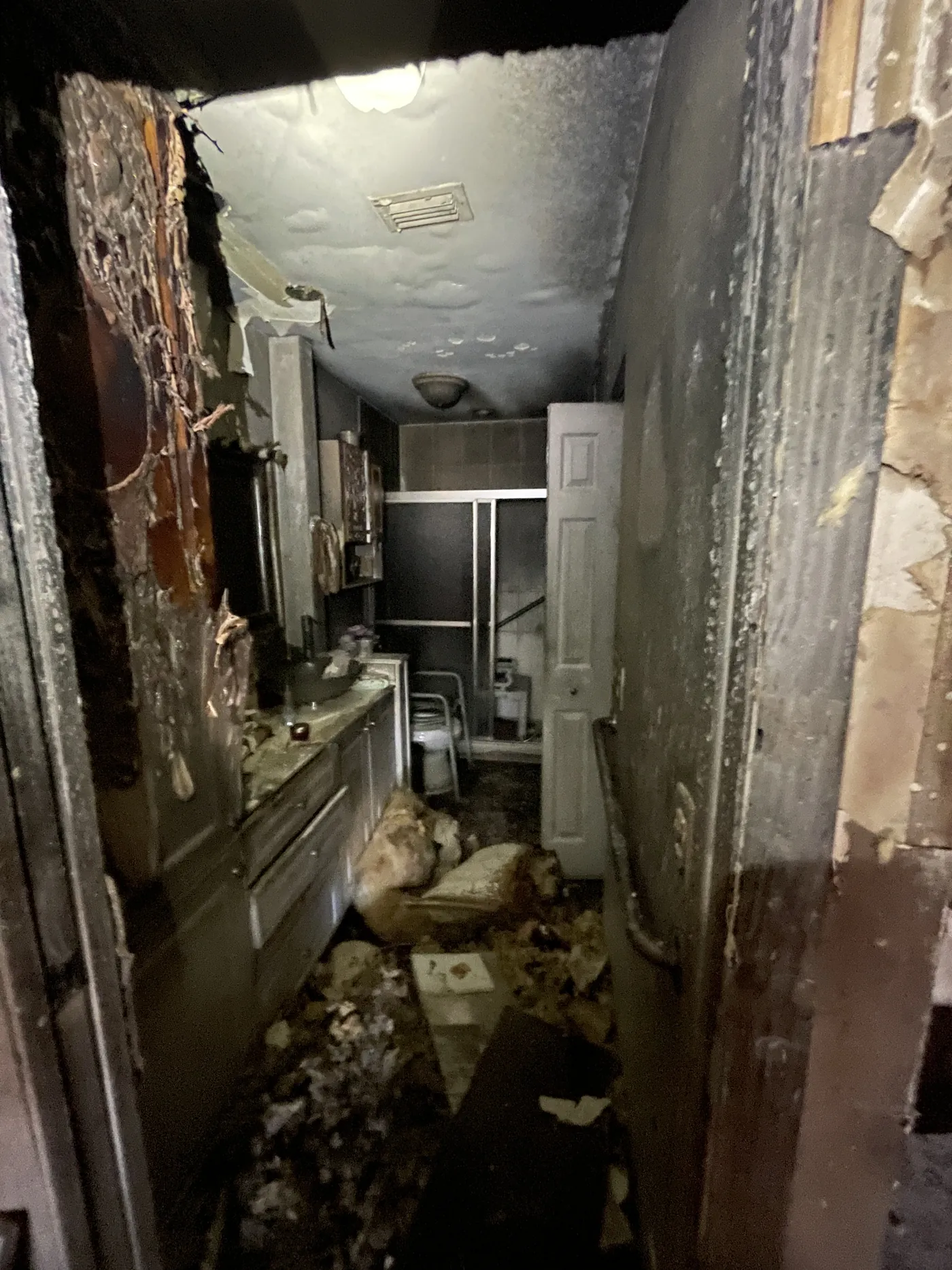 Charred cabinetry and heavy smoke residue in a kitchen after a house fire in West Palm Beach, FL