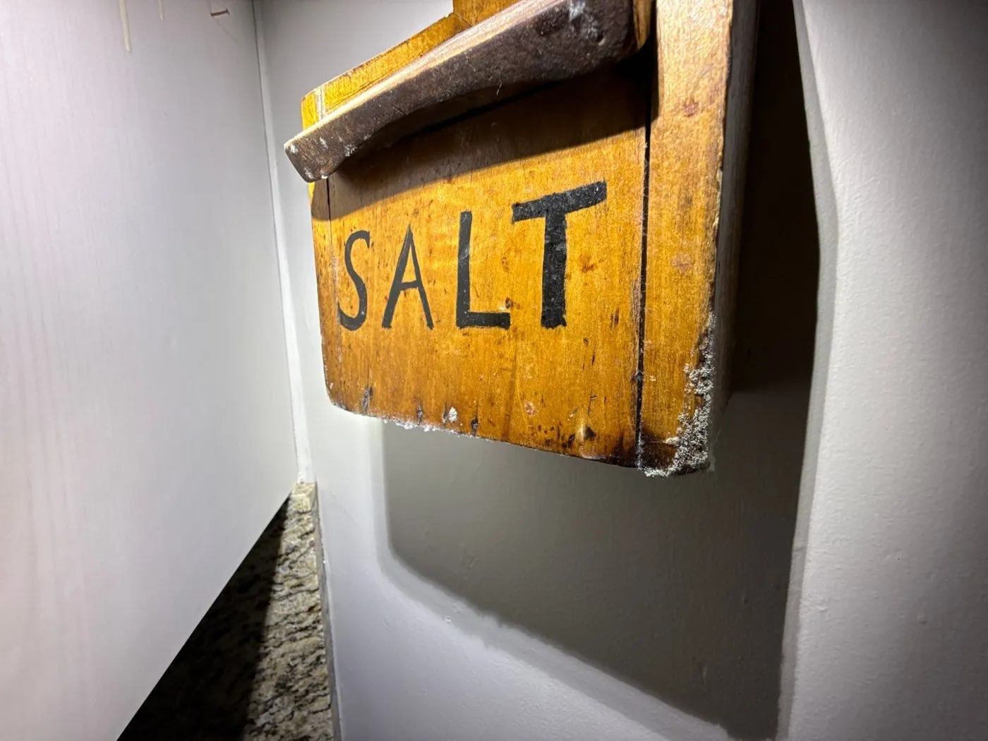 Wall-mounted wooden salt box with white crystalline deposits noted during a Fort Pierce, FL inspection